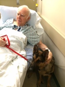 A man and his dog in hospital bed.