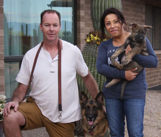 Couple with two dogs in outdoor setting.