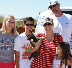 A family posing for a picture with their cat.