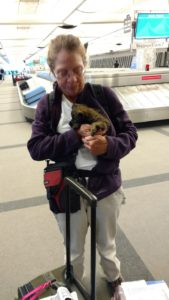A woman holding a small animal in her arms.