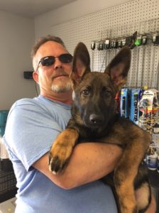 A man holding his dog in his arms.