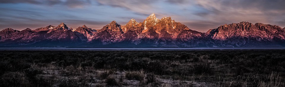 A mountain range with snow on it's side.