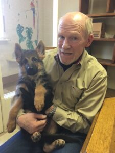 A man holding a dog in his arms.