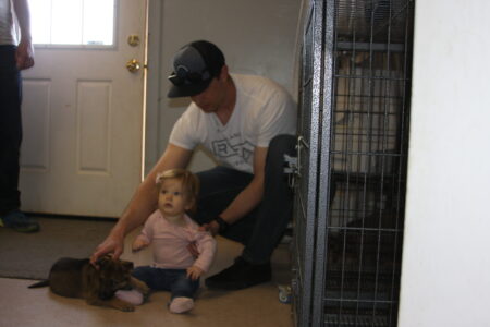A man and child in front of a cage.