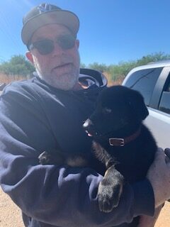 A man holding a dog in his arms.