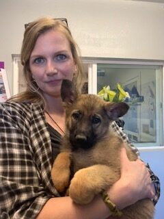 A woman holding a puppy in her arms.