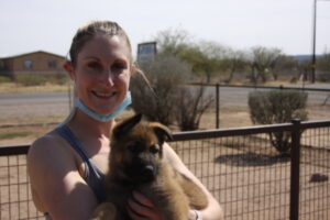 A woman holding a puppy in her arms.