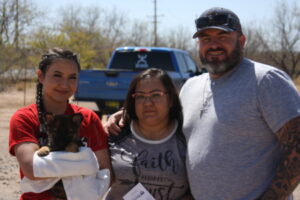 A family posing for the camera in front of a truck.