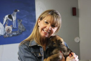 A woman holding a small dog in her arms.