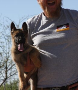 A man holding a dog in his arms.
