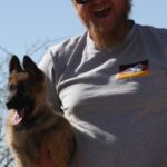 A man holding his dog in the air.