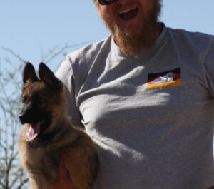 A man holding his dog in the air.