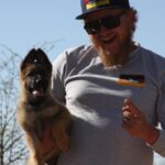 A man holding a dog in his arms.