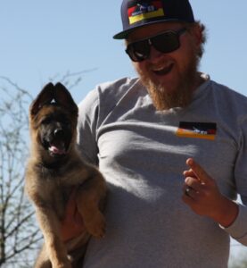 A man holding a dog in his arms.