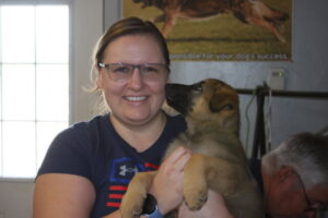 A woman holding a puppy in her arms.