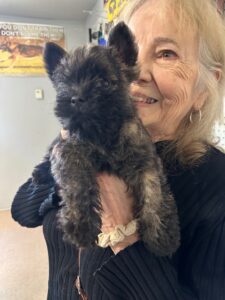 Woman holding a small fluffy dog.
